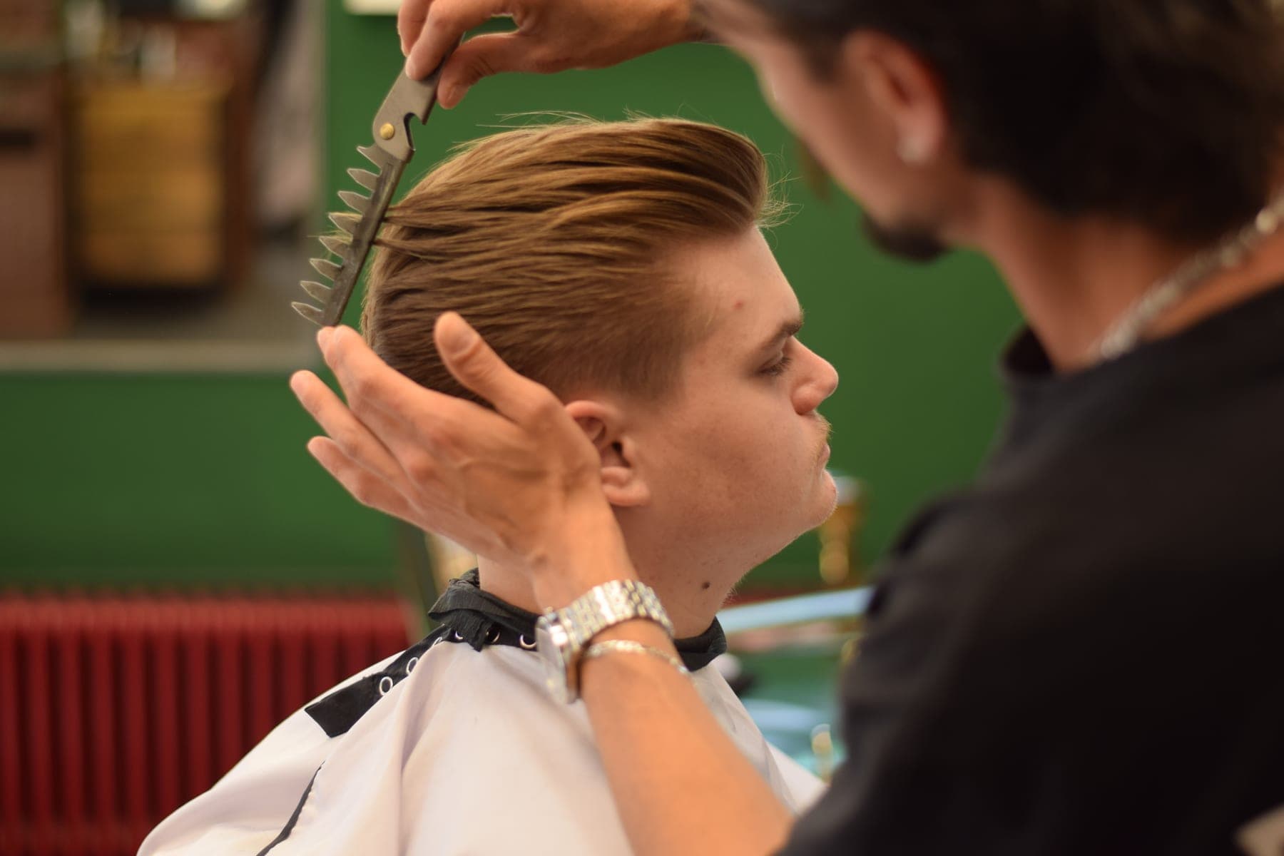 Schaar-over-kam werk aan een naar achteren gekamde quiff bij Porem Barbershop Amsterdam