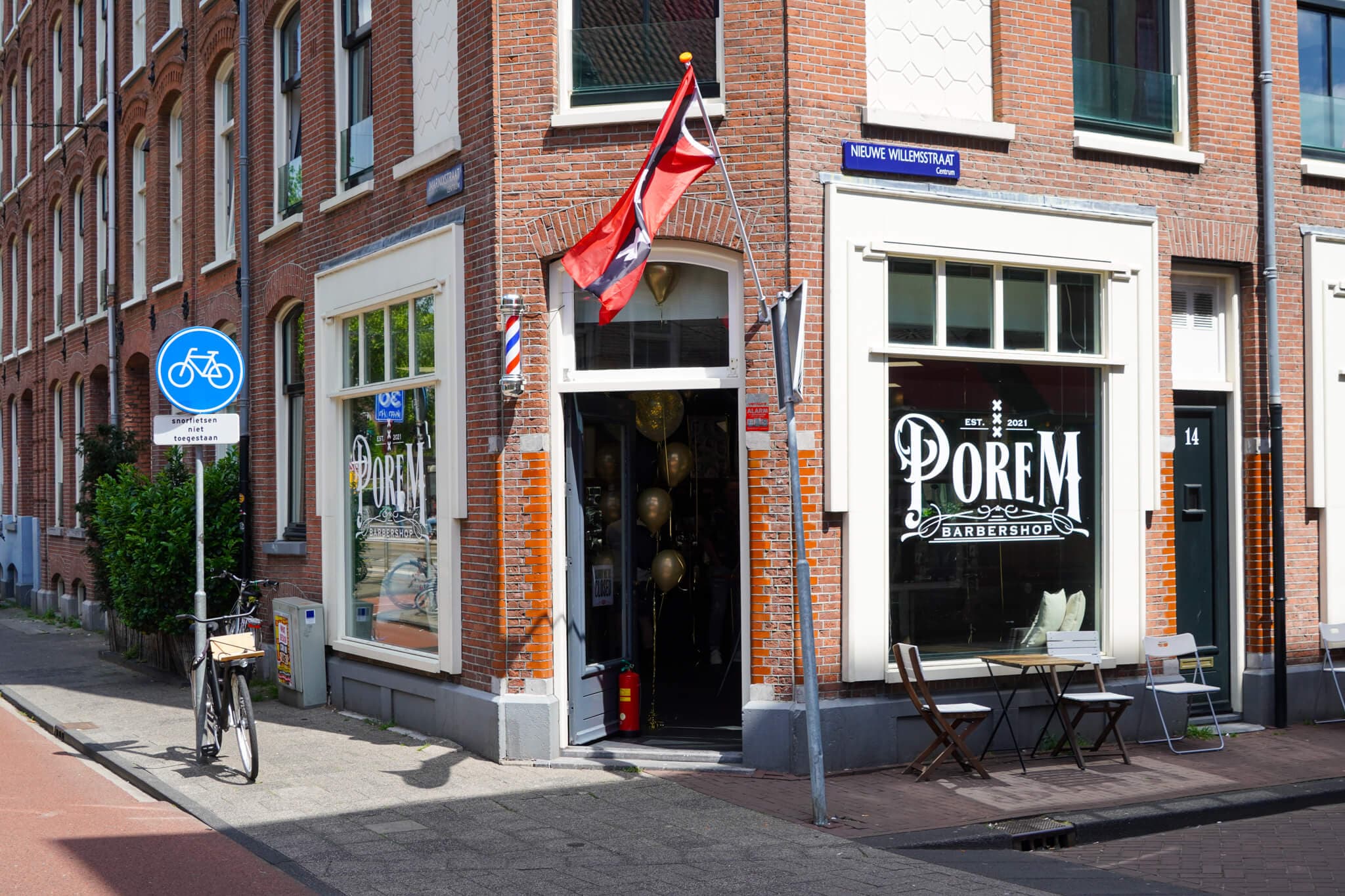 Porem Barbershop's Jordaan corner shop in Amsterdam, Amsterdam flag over the door